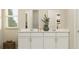 Bright bathroom featuring a double vanity with white cabinets and modern fixtures with a plant in a vase at 5786 Meditation Dr, Clermont, FL 34714