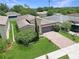 Aerial view of single-Gathering home, featuring a brick driveway, an attached garage, and lush green lawn at 9362 Oglethorpe Dr, Groveland, FL 34736