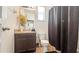 Cozy bathroom features a dark wood vanity, granite countertops, and a shower with a dark curtain at 9362 Oglethorpe Dr, Groveland, FL 34736