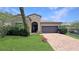 Beautiful single-story home with a brick driveway, attached two-car garage, and well manicured lawn at 9362 Oglethorpe Dr, Groveland, FL 34736