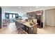 Open-concept kitchen with a central island, barstool seating, dark cabinetry and stainless steel appliances at 9362 Oglethorpe Dr, Groveland, FL 34736