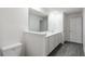 Bathroom featuring double sinks with white countertops, gray wood-look flooring, and a toilet at 628 Bay Leaf Dr, Poinciana, FL 34759