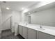 Elegant bathroom featuring double sinks with white countertops and gray wood-look flooring at 628 Bay Leaf Dr, Poinciana, FL 34759