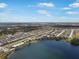 Expansive aerial view showing the community's layout, pool, lake, and surrounding landscape under a partly cloudy sky at 653 Vittorio Dr, Winter Haven, FL 33884