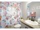 Pretty bathroom featuring floral shower curtain, neutral paint, gray countertops, and dark hardware at 653 Vittorio Dr, Winter Haven, FL 33884