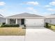 Charming single Gathering home featuring a two car garage, beautiful landscaping and a concrete driveway at 653 Vittorio Dr, Winter Haven, FL 33884