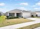 Charming single Gathering home featuring a two car garage, beautiful landscaping and a concrete driveway at 653 Vittorio Dr, Winter Haven, FL 33884