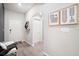 Bright foyer featuring a white interior door, laminate flooring, and minimalist decorative art hanging on the wall at 653 Vittorio Dr, Winter Haven, FL 33884