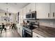 Modern kitchen with stainless steel appliances, white cabinets, granite counters, and an adjacent dining area at 653 Vittorio Dr, Winter Haven, FL 33884