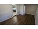 Spacious room with wood-look flooring leading to the kitchen and closet at 1804 S Mellonville Ave, Sanford, FL 32771