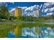 Scenic view of a lake with reflections of buildings and trees on a sunny day with cloudy skies at 2024 Count Ct, Lakeland, FL 33813