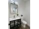 Stylish bathroom featuring a modern vanity with a gold faucet, a decorative mirror, and a toilet at 1897 West Pkwy, Deland, FL 32724