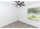 A simple bedroom with neutral tones, a ceiling fan, and a window at 1897 West Pkwy, Deland, FL 32724