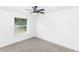 A simple bedroom with neutral tones, a ceiling fan, and a window at 1897 West Pkwy, Deland, FL 32724