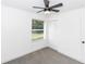 A simple bedroom with neutral tones, a ceiling fan, and a window at 1897 West Pkwy, Deland, FL 32724