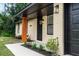 Inviting front entrance with a covered porch, new landscaping, and a freshly painted black front door at 1897 West Pkwy, Deland, FL 32724