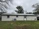 Exterior backyard featuring a metal roof, white siding, and a well-manicured lawn at 427 Donald St, Lakeland, FL 33813