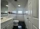 Tiled bathroom featuring a vanity, toilet, and shower-tub combination with updated fixtures at 427 Donald St, Lakeland, FL 33813