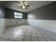 Bedroom with tiled floors, neutral paint, and a ceiling fan for added comfort at 427 Donald St, Lakeland, FL 33813