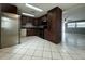 Traditional kitchen featuring dark wood cabinetry, a stainless steel refrigerator, and black appliances at 427 Donald St, Lakeland, FL 33813