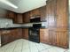 Traditional kitchen featuring dark wood cabinetry, a black backsplash, and black appliances at 427 Donald St, Lakeland, FL 33813