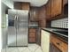 Traditional kitchen featuring dark wood cabinetry, a stainless steel refrigerator, and black appliances at 427 Donald St, Lakeland, FL 33813