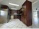 Traditional kitchen featuring dark wood cabinetry, a stainless steel refrigerator, and black appliances at 427 Donald St, Lakeland, FL 33813