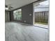 Living room with gray walls, ceiling fan, large window, and access to outdoor patio at 427 Donald St, Lakeland, FL 33813