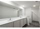 Modern bathroom featuring a dual sink vanity, a large mirror, and glass enclosed shower at 571 Bay Leaf Dr, Poinciana, FL 34759