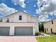 Charming two-story townhome features a brick driveway, two-car garage, and a well-maintained lawn at 571 Bay Leaf Dr, Poinciana, FL 34759