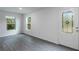 Bright living area with gray laminate flooring, windows, and a glass-paneled exterior door at 571 Bay Leaf Dr, Poinciana, FL 34759