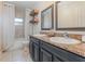 Well-lit bathroom featuring double sinks, granite countertops, and modern fixtures at 6214 Elm E Sq, Lakeland, FL 33813