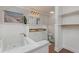 Bright bathroom featuring a jacuzzi tub, double sinks, and white wainscoting with wood-look tile flooring at 6214 Elm E Sq, Lakeland, FL 33813