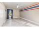 Neutral bedroom with ceiling fan, bright window with drapes, and red and blue accent stripe at 6214 Elm E Sq, Lakeland, FL 33813