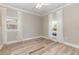 Bright bedroom with wood-look tile flooring, a ceiling fan, and two windows with white curtains at 6214 Elm E Sq, Lakeland, FL 33813