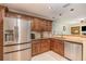 Kitchen featuring a stainless steel fridge, granite countertops, and wooden cabinetry at 6214 Elm E Sq, Lakeland, FL 33813