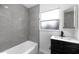 Modern bathroom featuring gray tile walls, sleek vanity, and a shower with a glass door at 2015 Poe St, Lakeland, FL 33801