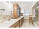 Bright bathroom with a double sink vanity, storage cabinet, and tiled shower at 2640 Oak Dr, Bartow, FL 33830