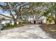 Long concrete driveway leading to a detached garage, all shaded by mature trees at 2640 Oak Dr, Bartow, FL 33830