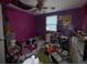 A dimly lit, disheveled bedroom showing standard window, pink walls, and cluttered space at 1710 Dana Pl, Lakeland, FL 33801