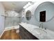 Renovated bathroom with a double vanity, a marble countertop, and tiled shower with glass door at 290 Ne 51St Ave, Ocala, FL 34470