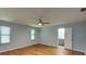 Airy bedroom with wood-look flooring, two windows, and ceiling fan; ensuite bathroom in view at 290 Ne 51St Ave, Ocala, FL 34470