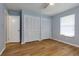 Well-lit bedroom with wood-look flooring, a window, and two large closets at 290 Ne 51St Ave, Ocala, FL 34470