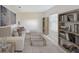 Bright living room featuring a comfortable sofa, bookshelves, and a contemporary glass coffee table at 4759 Golden Knight Blvd, Kissimmee, FL 34746