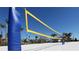Beach volleyball net with palm trees and neighborhood in background under a bright sky at 4777 Golden Knight Blvd, Kissimmee, FL 34746