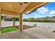 This covered patio features a brick floor, overhead fan, white fence and leads to green backyard at 390 Lisa Karen Cir, Apopka, FL 32712