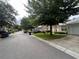 Quiet street lined with trees and well-maintained homes with driveways at 3079 Barbados Ln, Haines City, FL 33844