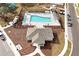 Aerial view of the community pool, sun-shades, lounge chairs, and recreation building at 5789 Timber Meadow Way, St Cloud, FL 34771