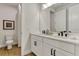 Modern bathroom featuring dual sinks, white cabinetry, quartz countertops and wood-look tile flooring at 5789 Timber Meadow Way, St Cloud, FL 34771