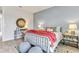 Stylized bedroom with a large, chunky knit throw blanket and a unique round mirror over a gray desk at 5789 Timber Meadow Way, St Cloud, FL 34771